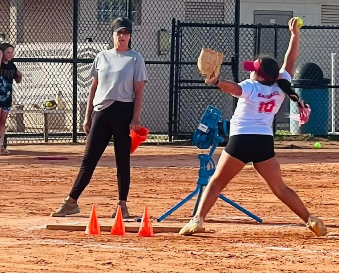 Coach Casey observing a pitcher during an outdoor lesson